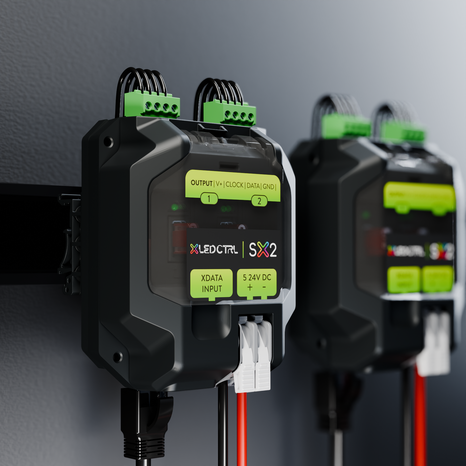 Two SX2 Long Range Receivers mounted side by side on DIN rail inside an equipment cabinet, pixel output terminal blocks wired along the top edge and the data input and quick-connect power clamps below